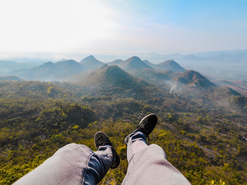 Feet dangling over the stunning landscape of Wonogiri Hills during sunrise, capturing the essence of Indonesian nature.