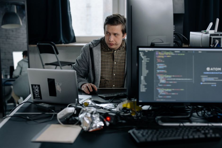 Programer u modernom uredu radi na kodu, fokusirana radna okolina